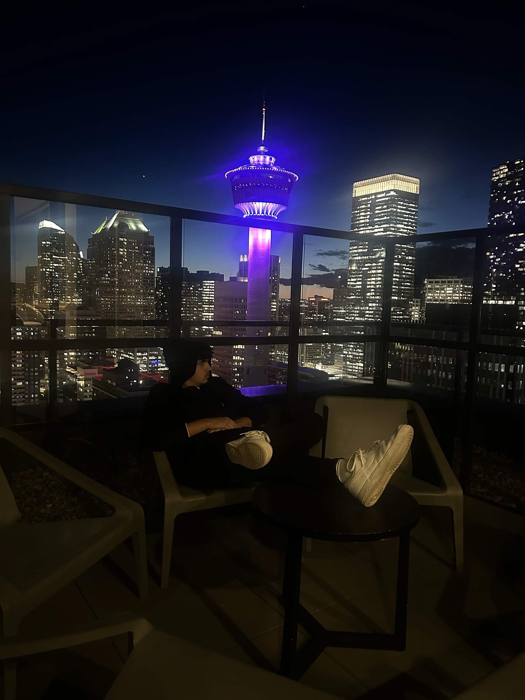 Noa Assaf on a Calgary rooftop at night with the Calgary Tower in view